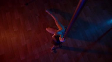Seksi kadın disko kulübünde direk dansı yapıyor. Direğin üstünde erotik dans. Egzotik direk dansı, striptizci, direk sporu, direk sanatı. Dansçı bir direğin etrafında kıvrılır ve döner. Baştan çıkarıcı striptizci akışkan hareketleriyle gölgelerde büyülenir..