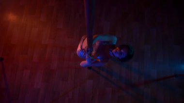 Seksi kadın disko kulübünde direk dansı yapıyor. Direğin üstünde erotik dans. Egzotik direk dansı, striptizci, direk sporu, direk sanatı. Dansçı bir direğin etrafında kıvrılır ve döner. Baştan çıkarıcı striptizci akışkan hareketleriyle gölgelerde büyülenir..