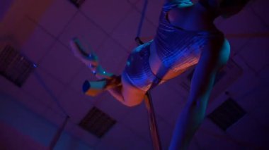 Seksi kadın disko kulübünde direk dansı yapıyor. Direğin üstünde erotik dans. Egzotik direk dansı, striptizci, direk sporu, direk sanatı. Dansçı bir direğin etrafında kıvrılır ve döner. Baştan çıkarıcı striptizci akışkan hareketleriyle gölgelerde büyülenir..