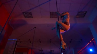 Seksi kadın disko kulübünde direk dansı yapıyor. Direğin üstünde erotik dans. Egzotik direk dansı, striptizci, direk sporu, direk sanatı. Dansçı bir direğin etrafında kıvrılır ve döner. Baştan çıkarıcı striptizci akışkan hareketleriyle gölgelerde büyülenir..