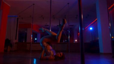 Seksi kadın disko kulübünde direk dansı yapıyor. Direğin üstünde erotik dans. Egzotik direk dansı, striptizci, direk sporu, direk sanatı. Dansçı bir direğin etrafında kıvrılır ve döner. Baştan çıkarıcı striptizci akışkan hareketleriyle gölgelerde büyülenir..