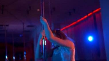 Seksi kadın disko kulübünde direk dansı yapıyor. Direğin üstünde erotik dans. Egzotik direk dansı, striptizci, direk sporu, direk sanatı. Dansçı bir direğin etrafında kıvrılır ve döner. Baştan çıkarıcı striptizci akışkan hareketleriyle gölgelerde büyülenir..