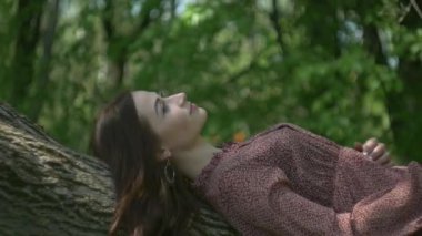 Zarif elbiseli bir kadın huzurlu bir orman ortamında yürüyor. Doğanın ortasında sakin bir kadın sahnesi. Ağaçlarla çevrili bir kadının huzurlu bir anı. Ormanın güzelliğinin ortasında bir dişi kaşif. Sakinleştirici bakış. 