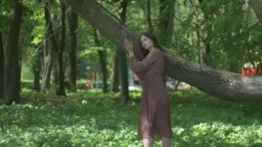 Zarif elbiseli bir kadın huzurlu bir orman ortamında yürüyor. Doğanın ortasında sakin bir kadın sahnesi. Ağaçlarla çevrili bir kadının huzurlu bir anı. Ormanın güzelliğinin ortasında bir dişi kaşif. Sakinleştirici bakış. 