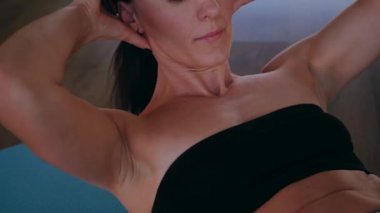 Bir kadın fiziksel egzersiz yapıyor. Genç bir kız kaslarını esneterek hücum eder. Spor salonunda spor mankeni. Güzel vücutlu bir kadın paspasın üzerinde fiziksel egzersiz yapar.. 