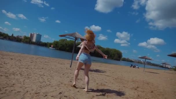 여자는 하늘의 배경에 해변에서 바카타 살사와 하늘을 뜨거운 모래에 매혹적으로 비디오 클립