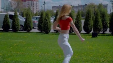 Güzel enerjik kadın dışarıda salsa yapıyor. Bachata yapan genç bir kadın, açık gökyüzünün altında parkta kizomba yapıyor. Şehrin kaldırımında ateşli bir kadının baştan çıkarıcı dansı..