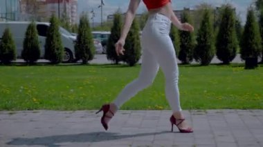 Güzel enerjik kadın dışarıda salsa yapıyor. Bachata yapan genç bir kadın, açık gökyüzünün altında parkta kizomba yapıyor. Şehrin kaldırımında ateşli bir kadının baştan çıkarıcı dansı..