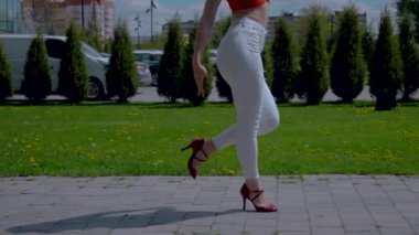 Güzel enerjik kadın dışarıda salsa yapıyor. Yavaş çekim. Bachata yapan genç bir kadın, açık gökyüzünün altında parkta kizomba yapıyor. Şehrin kaldırımında ateşli bir kadının baştan çıkarıcı dansı..