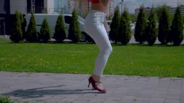 Güzel enerjik kadın dışarıda salsa yapıyor. Yavaş çekim. Bachata yapan genç bir kadın, açık gökyüzünün altında parkta kizomba yapıyor. Şehrin kaldırımında ateşli bir kadının baştan çıkarıcı dansı..