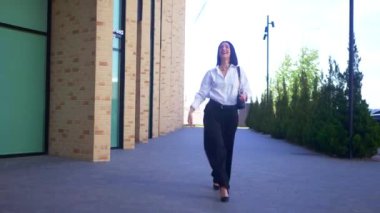 İş kadını, iş merkezinin yakınına menkul kıymetler bırakıyor. Ofis çalışanı, tatil, yönetmen, resmi kıyafetler. Beyaz gömlekli ve siyah pantolonlu mutlu bayan işini bitirdikten sonra değerli belgeleri sokağa saçıyor.. 