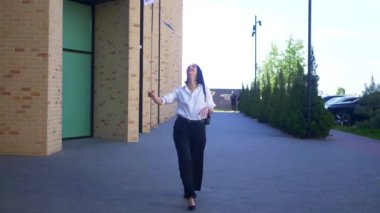 İş kadını, iş merkezinin yakınına menkul kıymetler bırakıyor. Ofis çalışanı, tatil, yönetmen, resmi kıyafetler. Beyaz gömlekli ve siyah pantolonlu mutlu bayan işini bitirdikten sonra değerli belgeleri sokağa saçıyor.. 