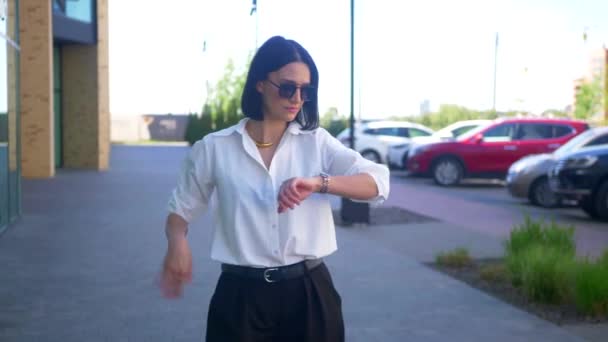 비즈니스 그녀의 시계를 사무원 형식적인 셔츠와 바지에 기업가 거리의 중간에 스톡 푸티지