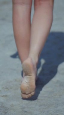 Sahilde bikinili genç bir kadın. Dikey. Esnek kalçalı bir kız kumsalda güneşleniyor. Çekici, ince model kameraya poz veriyor. Bikinili bir kadın kumsalda dinleniyor. Bikinili güzellik plaj havasından zevk alıyor..