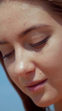 Sahilde bikinili genç bir kadın. Dikey. Esnek kalçalı bir kız kumsalda güneşleniyor. Çekici, ince model kameraya poz veriyor. Bikinili bir kadın kumsalda dinleniyor. Bikinili güzellik plaj havasından zevk alıyor..