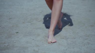 Güneşli sahilde bikinili genç bir kadın. Esnek kalçalı bir kız kumsalda güneşleniyor. Çekici, ince model kameraya poz veriyor. Bikinili bir kadın kumsalda dinleniyor. Bikinili güzellik plaj havasından zevk alıyor..