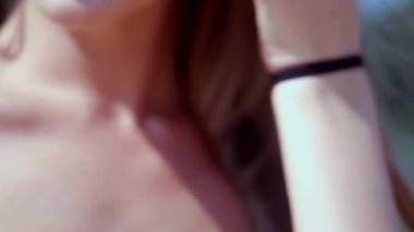 Güneşli sahilde bikinili genç bir kadın. Esnek kalçalı bir kız kumsalda güneşleniyor. Çekici, ince model kameraya poz veriyor. Bikinili bir kadın kumsalda dinleniyor. Bikinili güzellik plaj havasından zevk alıyor..