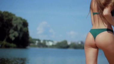 Güneşli sahilde bikinili genç bir kadın koşuyor. Esnek kalçalı bir kız kumsalda güneşleniyor. Çekici, ince model kameraya poz veriyor. Bikinili bir kadın kumsalda dinleniyor. Bikinili güzellik plaj havasından zevk alıyor..