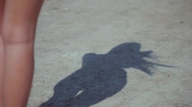 Güneşli sahilde bikinili genç bir kadın. Esnek kalçalı bir kız kumsalda güneşleniyor. Çekici, ince model kameraya poz veriyor. Bikinili bir kadın kumsalda dinleniyor. Bikinili güzellik plaj havasından zevk alıyor..