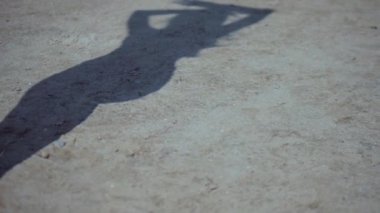 Güneşli sahilde bikinili genç bir kadın. Esnek kalçalı bir kız kumsalda güneşleniyor. Çekici, ince model kameraya poz veriyor. Bikinili bir kadın kumsalda dinleniyor. Bikinili güzellik plaj havasından zevk alıyor..