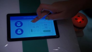 Masaj cihazının yakın çekim görüntüsü. Tıbbi cihaz tableti. Parmak dokunmatik pede basılır. Ekrana dokun