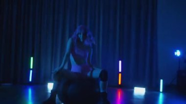 Anime tarzı pembe peruklu genç bir kadın loş ışıklı neon bir odada erotik dans eden bir twerk. Yarı tıraşlı bir kız karanlık uzayda zarifçe hareket ediyor. Sahnedeki bir disko kulübünde striptiz. Gölgeye karşı siluetlenmiş kadın dansçı şerefine. 