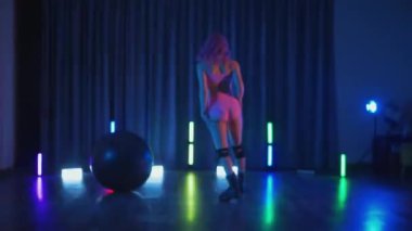 Anime tarzı pembe peruklu genç bir kadın loş ışıklı neon bir odada erotik dans eden bir twerk. Yarı tıraşlı bir kız karanlık uzayda zarifçe hareket ediyor. Sahnedeki bir disko kulübünde striptiz. Gölgeye karşı siluetlenmiş kadın dansçı şerefine. 