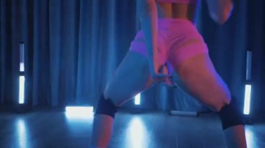 Anime tarzı pembe peruklu genç bir kadın loş ışıklı neon odada erotik bir şekilde dans ediyor. Pembe iç çamaşırı. Yarı tıraşlı bir kız karanlık uzayda zarifçe hareket ediyor. Sahnedeki bir disko kulübünde striptiz. Şerefe kadın dansçı, yavaş çekim.