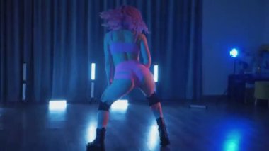 Anime tarzı pembe peruklu genç bir kadın loş ışıklı neon odada erotik bir şekilde dans ediyor. Pembe iç çamaşırı. Yarı tıraşlı bir kız karanlık uzayda zarifçe hareket ediyor. Sahnedeki bir disko kulübünde striptiz. Şerefe kadın dansçı, yavaş çekim.