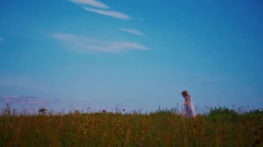 Mavi elbiseli küçük bir kız güneşli bir alanda mutlu mesut duruyor. Açık mavi elbiseli genç bir kız bir tarlada uzun otlarla çevrili olarak yürüyor. Resimli bir tarlada oynayan mavi elbiseli küçük bir kız. Mavi elbiseli bir çocuk, neşeyle