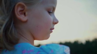 Mavi elbiseli küçük bir kız güneşli bir alanda mutlu mesut duruyor. Açık mavi elbiseli genç bir kız bir tarlada uzun otlarla çevrili olarak yürüyor. Resimli bir tarlada oynayan mavi elbiseli küçük bir kız. Mavi elbiseli bir çocuk, neşeyle