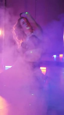 Dikey. Seksi kadın disko kulübünde direk dansı yapıyor. Direğin üstünde erotik dans. Egzotik direk dansı, striptizci, direk sporu, direk sanatı. Duman makinesi, lazer..