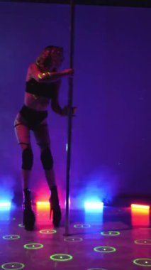 Dikey. Seksi kadın disko kulübünde direk dansı yapıyor. Direğin üstünde erotik dans. Egzotik direk dansı, striptizci, direk sporu, direk sanatı. Duman makinesi, lazer..