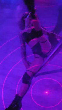 Dikey. Seksi kadın disko kulübünde direk dansı yapıyor. Direğin üstünde erotik dans. Egzotik direk dansı, striptizci, direk sporu, direk sanatı. Duman makinesi, lazer..