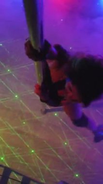 Dikey. Seksi kadın disko kulübünde direk dansı yapıyor. Direğin üstünde erotik dans. Egzotik direk dansı, striptizci, direk sporu, direk sanatı. Duman makinesi, lazer..