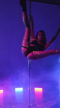 Dikey. Seksi kadın disko kulübünde direk dansı yapıyor. Direğin üstünde erotik dans. Egzotik direk dansı, striptizci, direk sporu, direk sanatı. Duman makinesi, lazer..