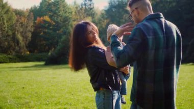 Aile pikniği, altın güneş ışığı banyosu, parkta elmaları ve kahkahaları paylaşmak. Sıcak bir sonbahar öğleden sonrasında, bir aile çimlerin üzerinde basit bir pikniğin tadını çıkarıyor. Tatlı gülüşler ve paylaşılan elmalar, parkta bir ailenin neşesi. Aile bağları güçlenir. 