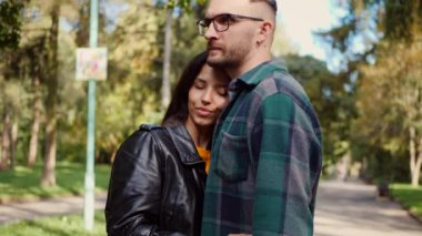 Güneşten sırılsıklam olmuş bir parkta bir erkekle bir kadının yakın kucaklaşması. Mutlu sevgili çift, sonbahar yaprakları arasında hassas bir anı paylaşıyor. Yüzler birbirine yakın, parkın kollarında bir bağ hissedildi. Sessiz bir park ortamında samimiyet ve samimiyet. Bir park karşılaşması, aşkım. 