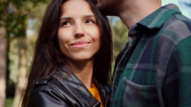 Güneşten sırılsıklam olmuş bir parkta bir erkekle bir kadının yakın kucaklaşması. Mutlu sevgili çift, sonbahar yaprakları arasında hassas bir anı paylaşıyor. Yüzler birbirine yakın, parkın kollarında bir bağ hissedildi. Sessiz bir park ortamında samimiyet ve samimiyet. Bir park karşılaşması, aşkım. 