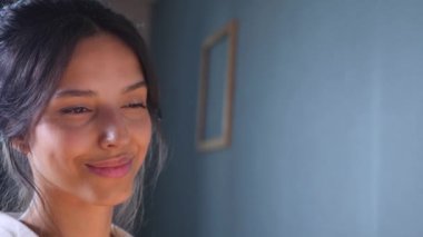 Gülümseyen bir sanatçı sehpaya resim çizer. Mutlu bir kadın tuvalde bir resim yaratıyor. Kadın, sanat stüdyosundaki beyaz kağıda gülüyor ve soyutlama çiziyor..
