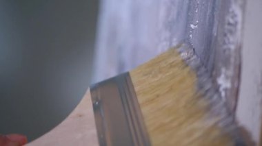 Bir resim çizen bir fırçanın yakın çekimi. Sanatçı tuvalde bir resim yaratıyor. Bir kadın, bir sanat stüdyosundaki beyaz kağıda soyut bir resim çiziyor..