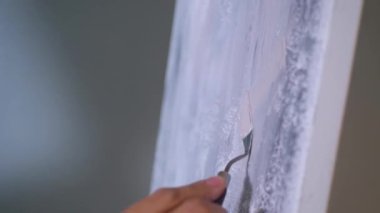Sanatçı, sehpada beyaz bir tuval üzerinde bir fırça ile soyut bir tablo çizer. Beyaz bluzlu bir kadın stüdyoda parlak renklerle bir resim çiziyor. Sanatçının eli zarafetle hareket eder, tuvale bir güzellik sahnesi çizer. 
