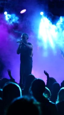 Dikey, kulüpte Rock konseri. Gece kulübü partisi. Rock grubu rock festivalinde çalıyor. İnsanlar rock dinler..