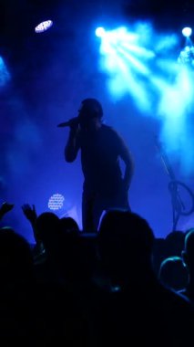 Dikey, kulüpte Rock konseri. Gece kulübü partisi. Rock grubu rock festivalinde çalıyor. İnsanlar rock dinler..