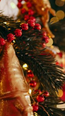 Dikey. Geleneksel Noel ağacı kırmızı süslemelerle süslenmiş. Güzel dekore edilmiş Noel ağacı olan şenlik odası. Kırmızı takılar bir tatil ağacına renk katıyor. Samimi ayarlar