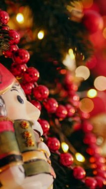 Dikey. Geleneksel Noel ağacı kırmızı süslemelerle süslenmiş. Güzel dekore edilmiş Noel ağacı olan şenlik odası. Kırmızı takılar bir tatil ağacına renk katıyor. Samimi ayarlar