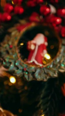 Dikey. Geleneksel Noel ağacı kırmızı süslemelerle süslenmiş. Güzel dekore edilmiş Noel ağacı olan şenlik odası. Kırmızı takılar bir tatil ağacına renk katıyor. Samimi ayarlar