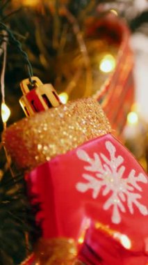 Dikey. Geleneksel Noel ağacı kırmızı süslemelerle süslenmiş. Güzel dekore edilmiş Noel ağacı olan şenlik odası. Kırmızı takılar bir tatil ağacına renk katıyor. Samimi ayarlar