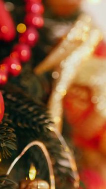 Dikey. Geleneksel Noel ağacı kırmızı süslemelerle süslenmiş. Güzel dekore edilmiş Noel ağacı olan şenlik odası. Kırmızı takılar bir tatil ağacına renk katıyor. Samimi ayarlar