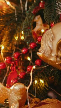 Dikey. Geleneksel Noel ağacı kırmızı süslemelerle süslenmiş. Güzel dekore edilmiş Noel ağacı olan şenlik odası. Kırmızı takılar bir tatil ağacına renk katıyor. Samimi ayarlar